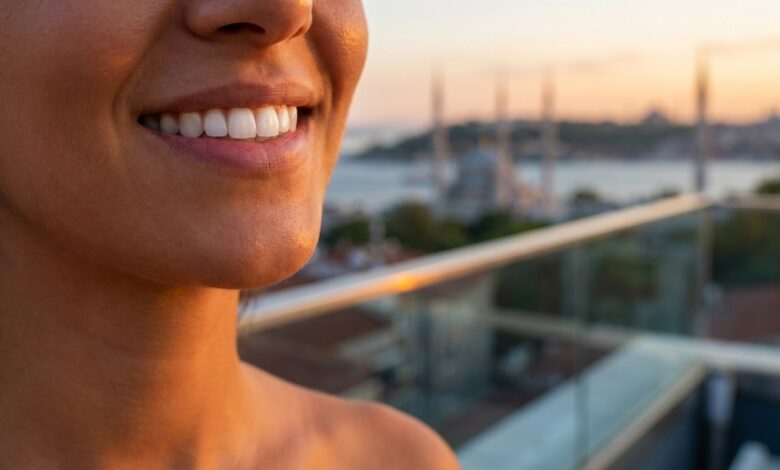 Eine Nahaufnahme eines perfekten, weißen Lächelns. Im unscharfen Hintergrund ist die malerische Skyline von Istanbul bei Sonnenuntergang zu sehen, was das Thema Zahntourismus in die Türkei visualisiert.