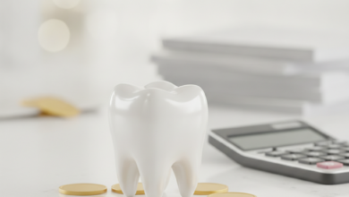 Eine Nahaufnahme eines stilisierten, gesunden Zahns auf einem hellen Schreibtisch, umgeben von unscharfen Münzen und einem nicht lesbaren Rechner, die die finanziellen Aspekte von Zahnbehandlungen und Krankenkassen-Erstattungen symbolisieren. Der Hintergrund ist weich gezeichnet, ohne sichtbaren Text.